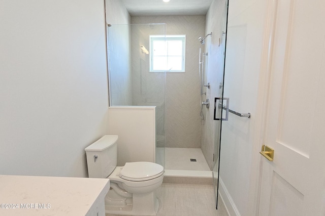 bathroom featuring tile patterned flooring, toilet, and a shower with door