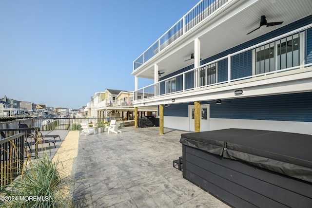 view of patio / terrace featuring a balcony, a hot tub, and ceiling fan