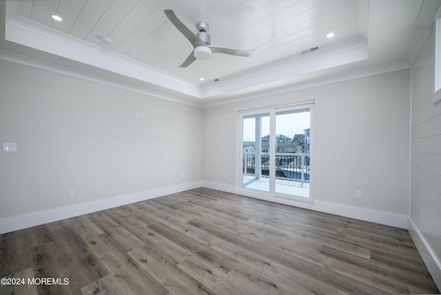 unfurnished room with ceiling fan, wood-type flooring, ornamental molding, and a tray ceiling