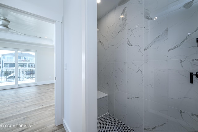 bathroom with hardwood / wood-style flooring and tiled shower