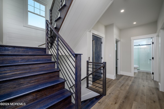 stairs with hardwood / wood-style floors and a barn door