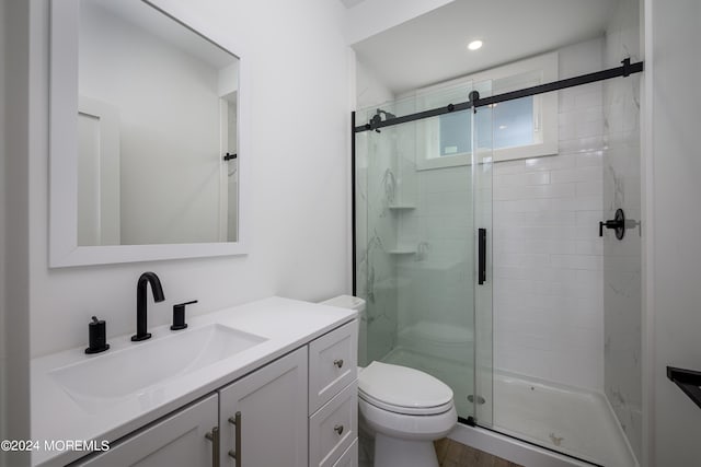 bathroom featuring vanity, toilet, and an enclosed shower