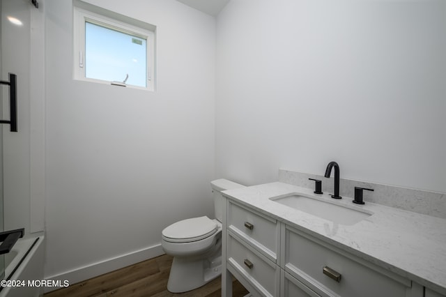 bathroom featuring hardwood / wood-style floors, vanity, and toilet