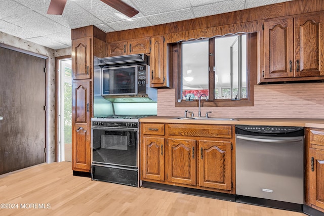 kitchen featuring stove, stainless steel dishwasher, light wood-type flooring, and sink