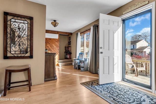 entrance foyer featuring a wall mounted air conditioner and light hardwood / wood-style floors