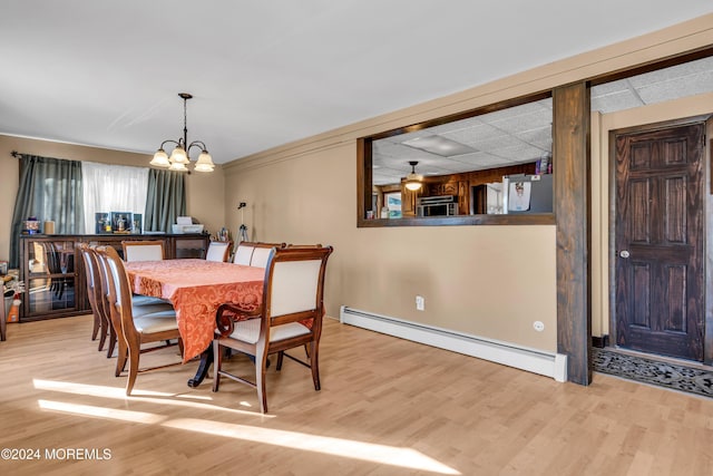 dining space with light hardwood / wood-style flooring, a baseboard radiator, and a notable chandelier