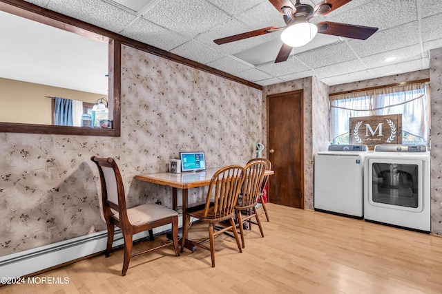 dining area featuring light hardwood / wood-style flooring, a drop ceiling, a baseboard heating unit, and independent washer and dryer