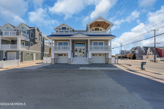 view of front of house featuring french doors, a balcony, and a garage