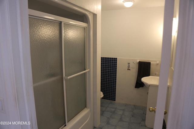 bathroom with tile patterned floors, vanity, toilet, and tile walls