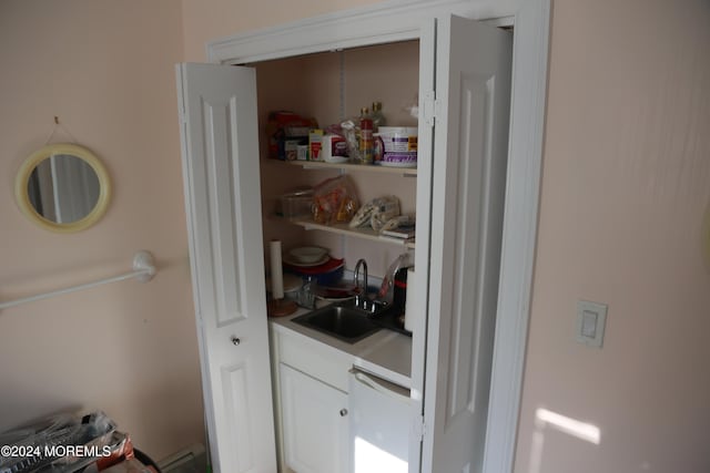 pantry with baseboard heating and sink