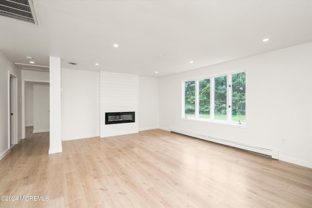 unfurnished living room with a large fireplace, light hardwood / wood-style floors, and a baseboard radiator