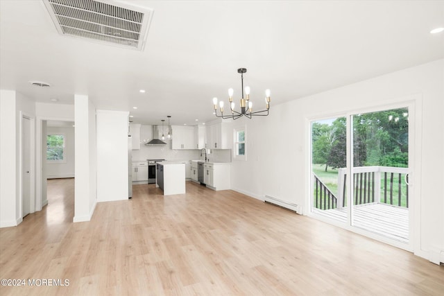 unfurnished living room with an inviting chandelier, light hardwood / wood-style flooring, a baseboard heating unit, and sink