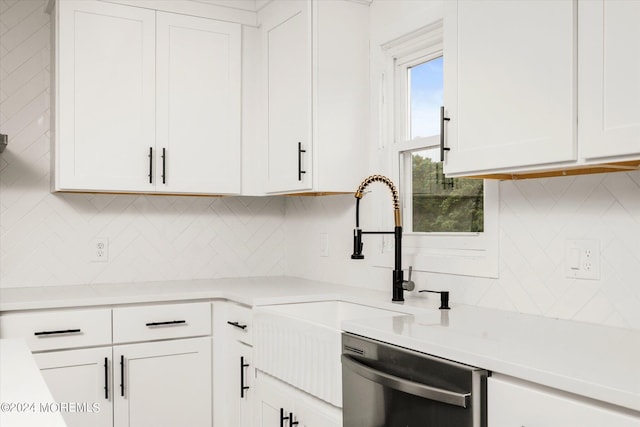 kitchen featuring dishwasher, tasteful backsplash, and white cabinetry