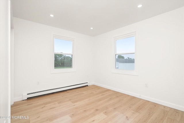 empty room with light wood-type flooring and baseboard heating