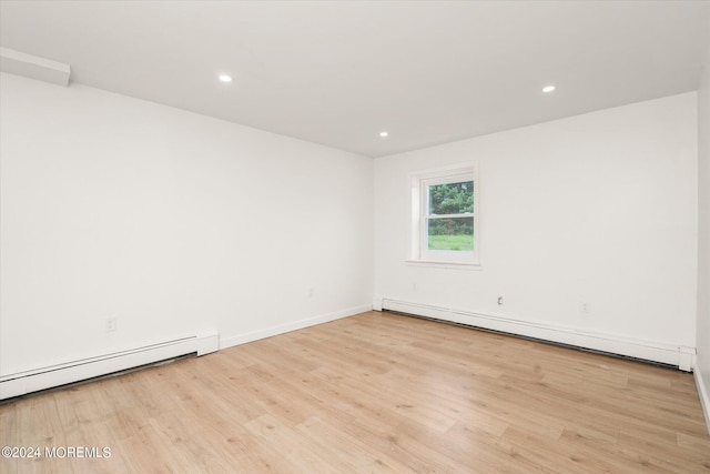 empty room featuring light hardwood / wood-style floors and baseboard heating