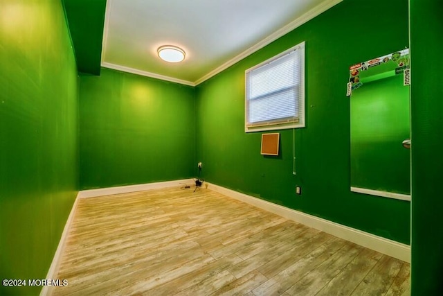 spare room featuring hardwood / wood-style floors and crown molding