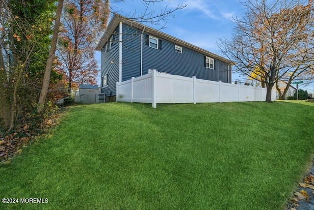 back of house with a yard and central AC unit