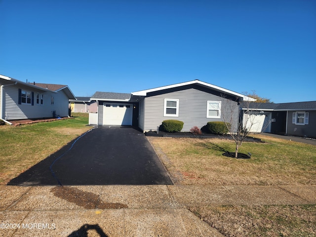 single story home with a garage and a front lawn