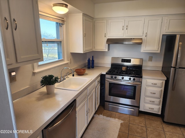 kitchen with light tile patterned floors, stainless steel appliances, white cabinetry, and sink