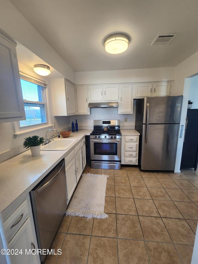 kitchen with light tile patterned flooring, white cabinetry, sink, and appliances with stainless steel finishes