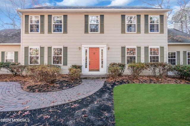 colonial house featuring a front lawn