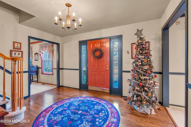 entryway with wood-type flooring and a notable chandelier