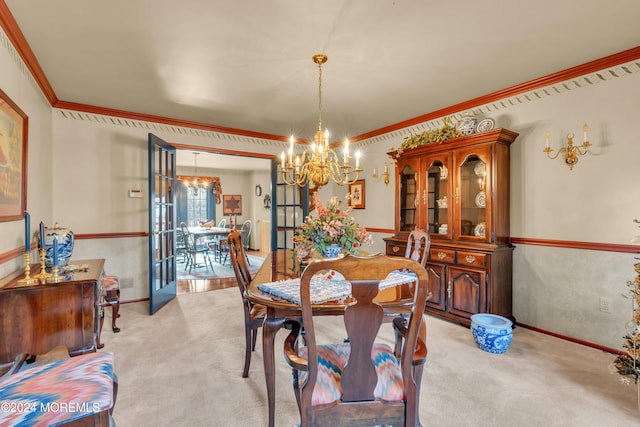 dining room featuring crown molding, french doors, light colored carpet, and an inviting chandelier