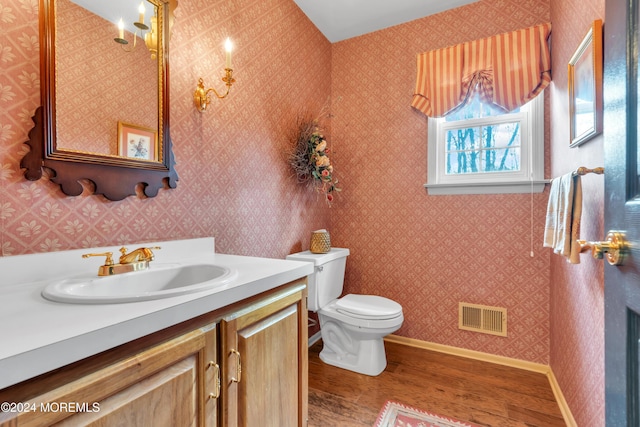 bathroom featuring toilet, vanity, and hardwood / wood-style flooring