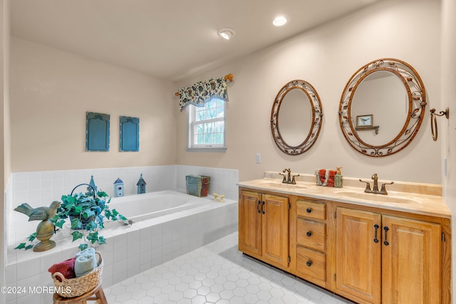 bathroom with tile patterned floors, vanity, and tiled tub