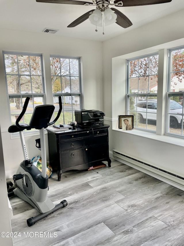 interior space featuring ceiling fan, light hardwood / wood-style flooring, and a baseboard heating unit