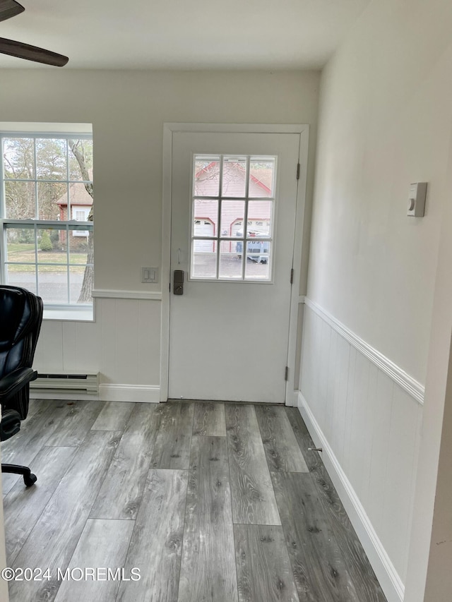 doorway featuring hardwood / wood-style floors, a baseboard radiator, and ceiling fan