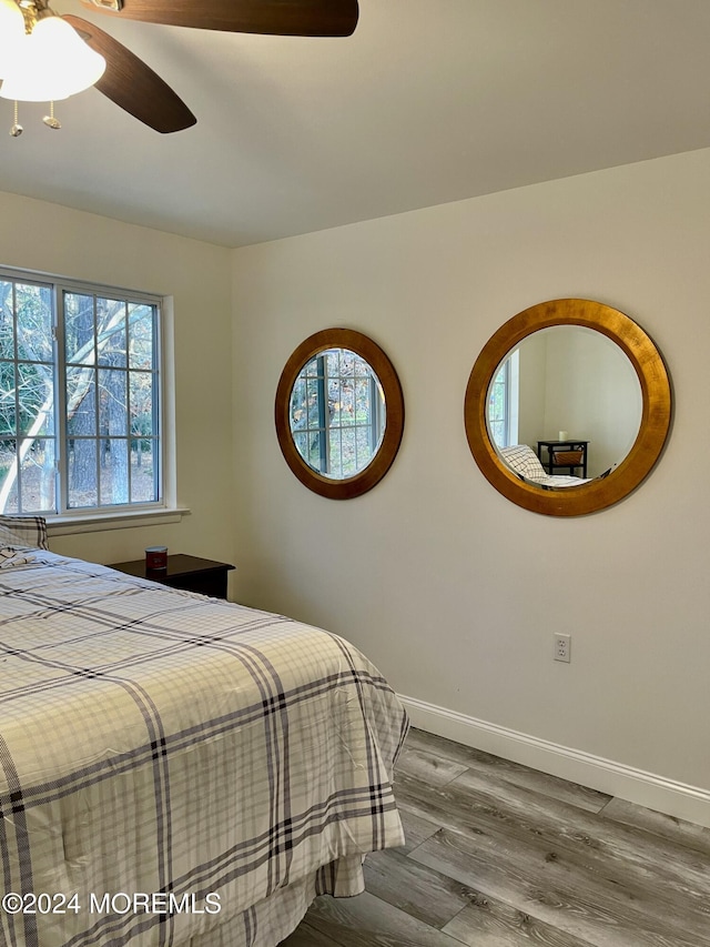 bedroom featuring multiple windows, ceiling fan, and hardwood / wood-style floors