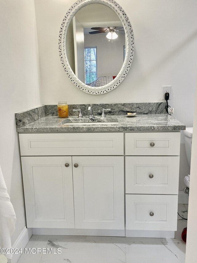 bathroom featuring vanity, toilet, and ceiling fan