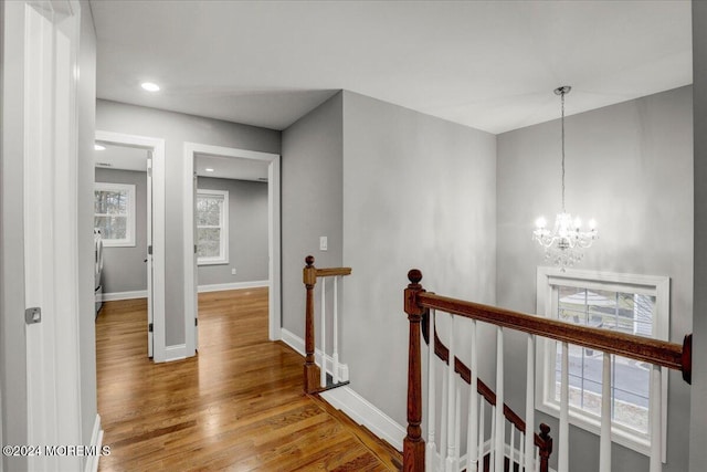 hallway with a chandelier and wood-type flooring