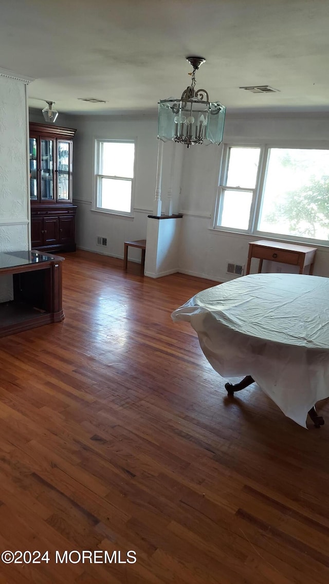 unfurnished dining area featuring a chandelier, dark wood-type flooring, and pool table