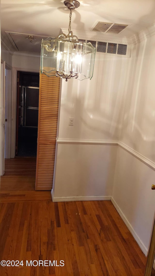 unfurnished dining area featuring hardwood / wood-style floors and an inviting chandelier