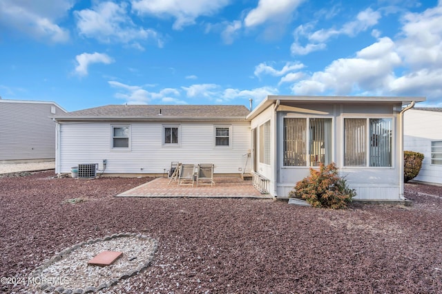 rear view of property featuring a patio area, a sunroom, and central AC unit