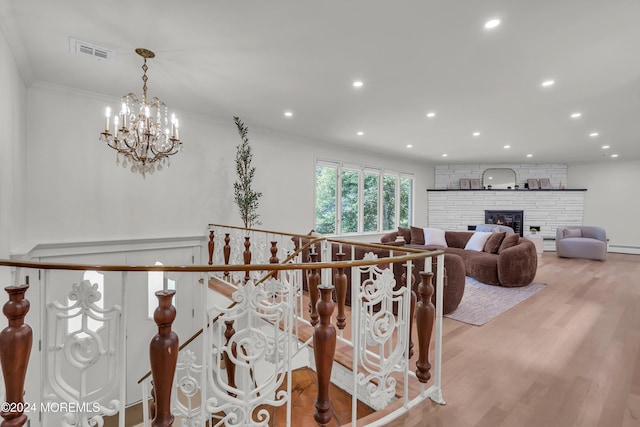 interior space with an inviting chandelier, light wood-type flooring, and ornamental molding