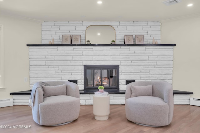 interior space featuring a fireplace, hardwood / wood-style floors, a baseboard radiator, and ornamental molding