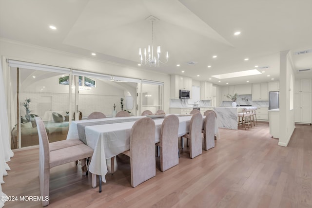 dining room featuring crown molding, an inviting chandelier, and light wood-type flooring