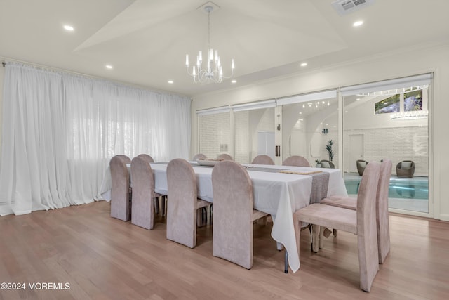 dining space featuring vaulted ceiling, a notable chandelier, and light wood-type flooring