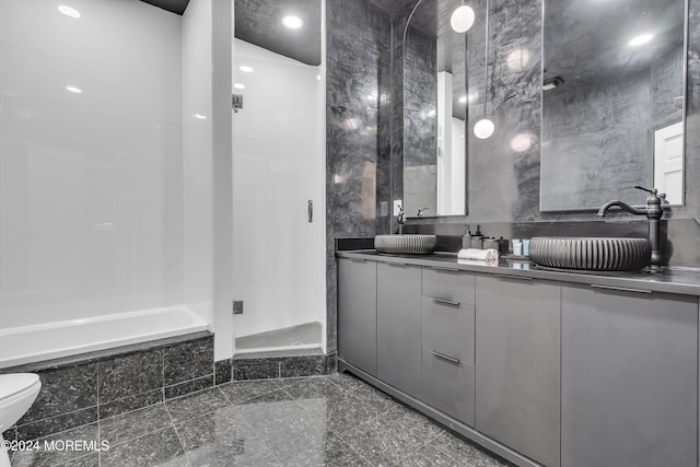 full bathroom with toilet, vanity, separate shower and tub, and tile walls