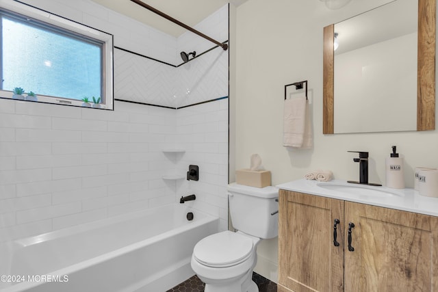 full bathroom with tiled shower / bath, vanity, and toilet