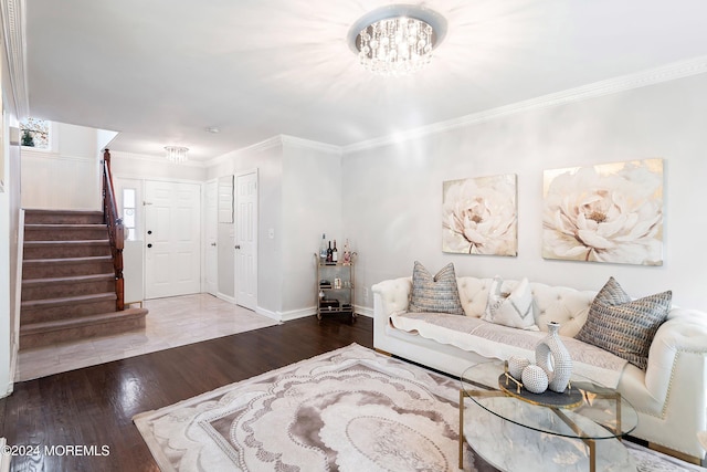 living room featuring hardwood / wood-style flooring, ornamental molding, and an inviting chandelier