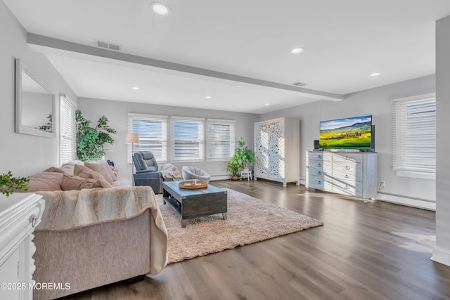 living room featuring beam ceiling, baseboard heating, and dark wood-type flooring