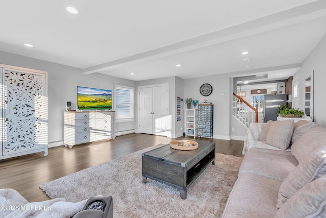 living room with wood-type flooring, baseboard heating, and beam ceiling