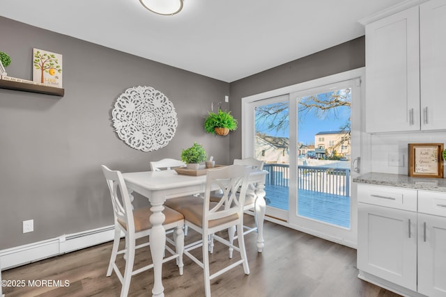 dining room with a baseboard heating unit and dark wood-type flooring