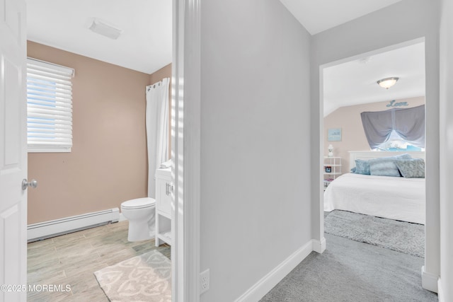 bathroom with toilet, a baseboard radiator, and lofted ceiling