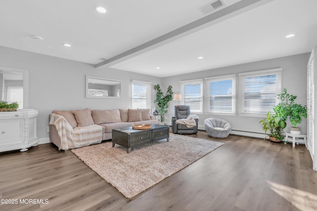 living room with baseboard heating, beamed ceiling, and wood-type flooring