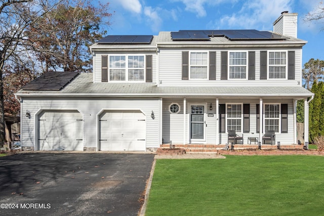 view of front of house with covered porch, solar panels, and a front lawn